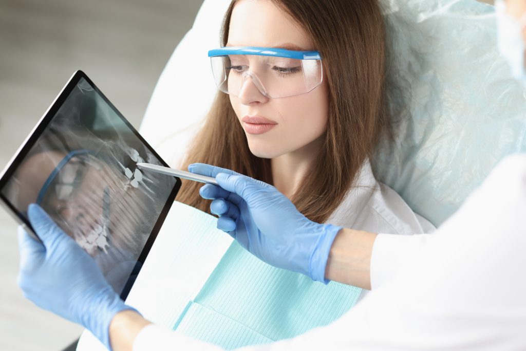 Patient on consultation in clinic, doctor explain problem with teeth