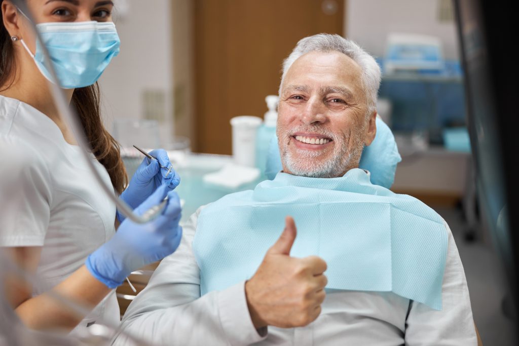 Cheerful aged man feeling great during a dental check-up